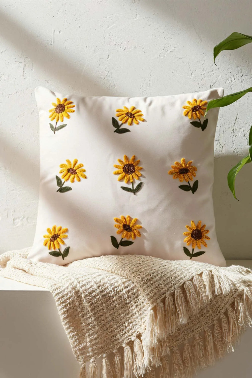 Cremefarbener Hintergrund, Sonnenblumenmuster, dekorativer Leinenkissenbezug mit Lochstickerei.
