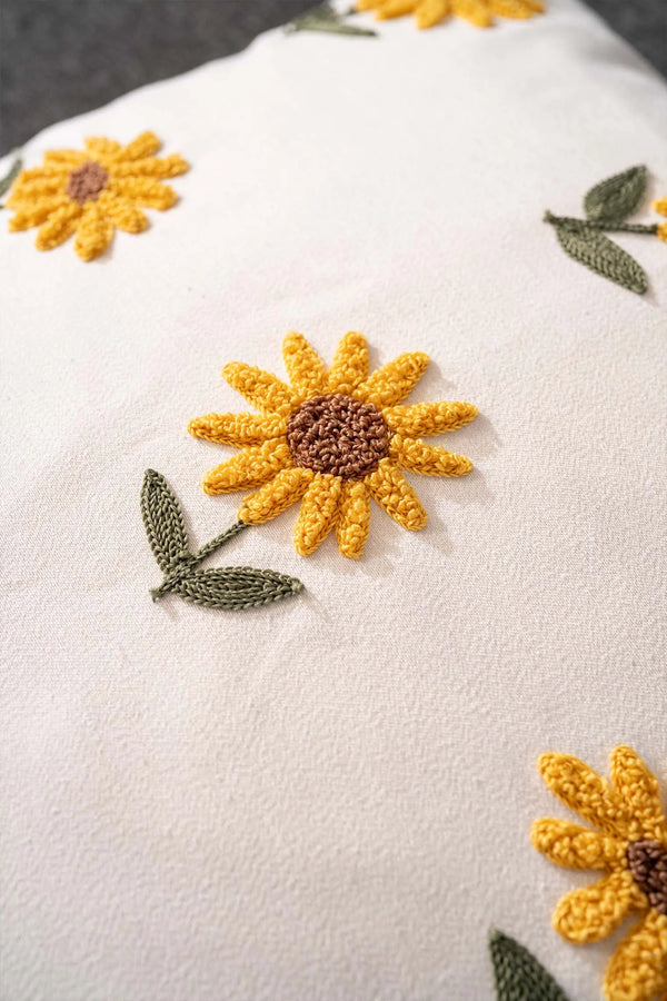 Cremefarbener Hintergrund, Sonnenblumenmuster, dekorativer Leinenkissenbezug mit Lochstickerei.